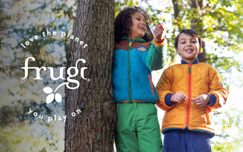 Three children sitting on a stairs wearing bright organic cotton clothing